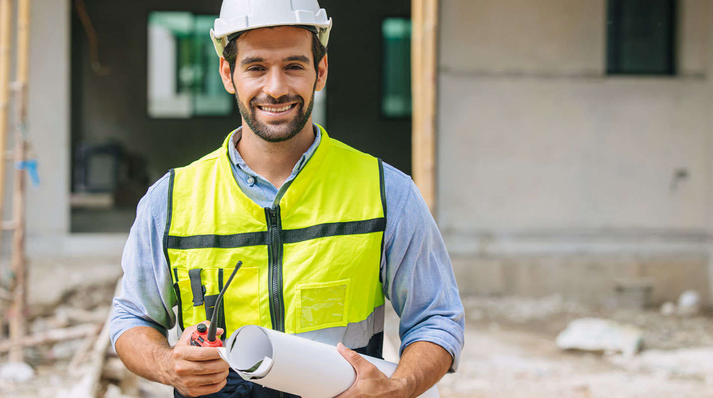 Un artisan du bâtiment examine une cloison lors d'une évaluation avant travaux dans une maison ancienne